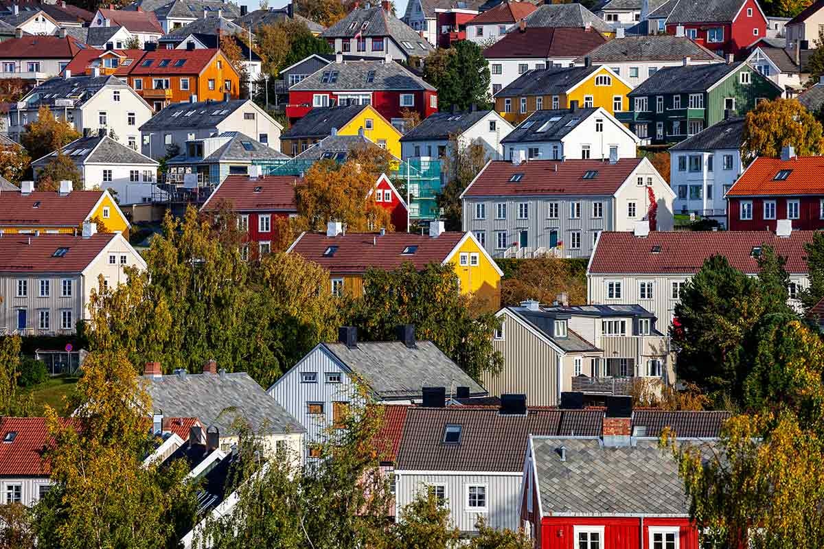Kvinne sitter på kjøkkenbordet og forbereder seg til å kjøpe bolig
