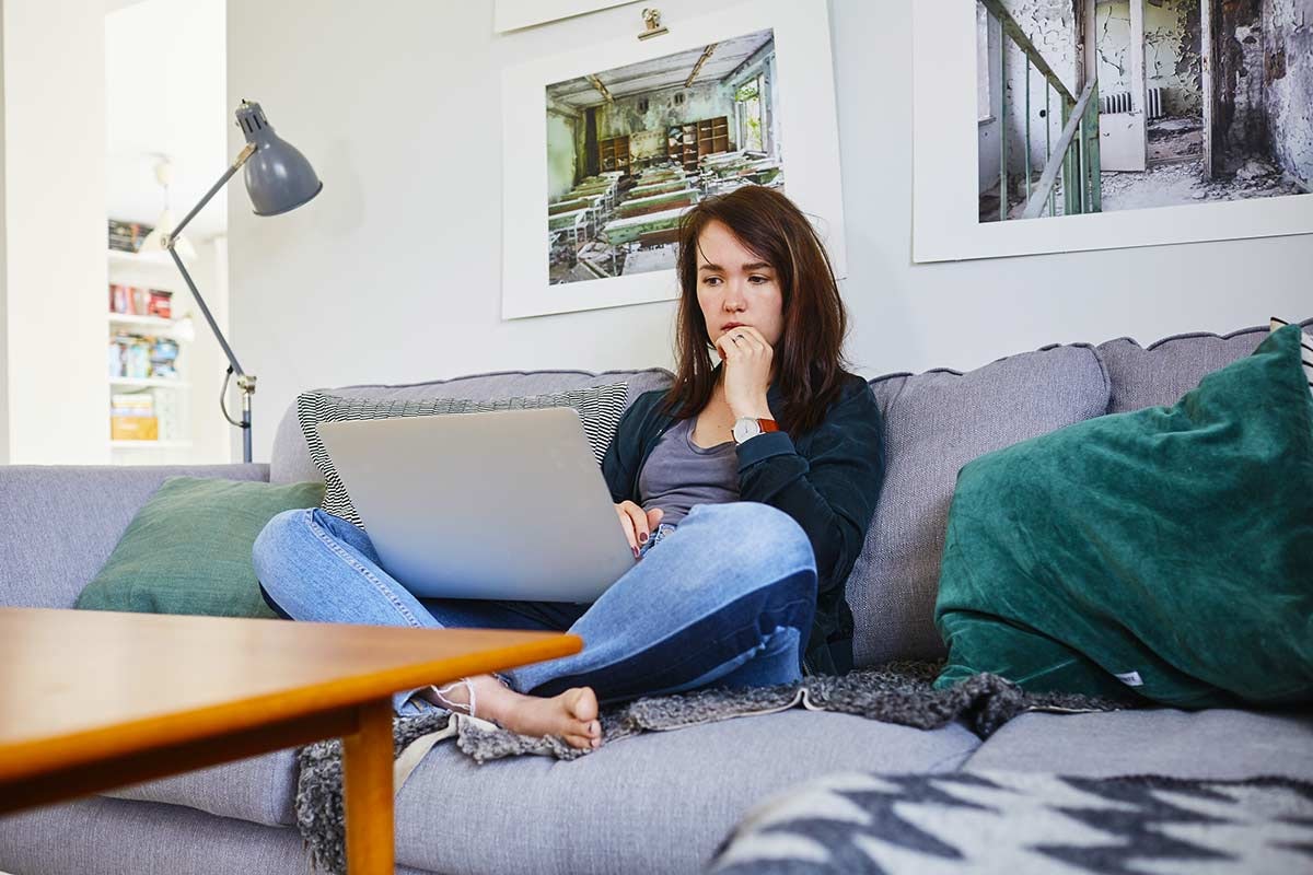 Dame søker etter bolig på pc, til illustrasjon for når er det best å kjøpe bolig