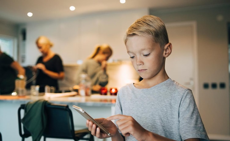 Gutt ser på mobiltelefonen sin, til illustrasjon for mine kort appen til barn