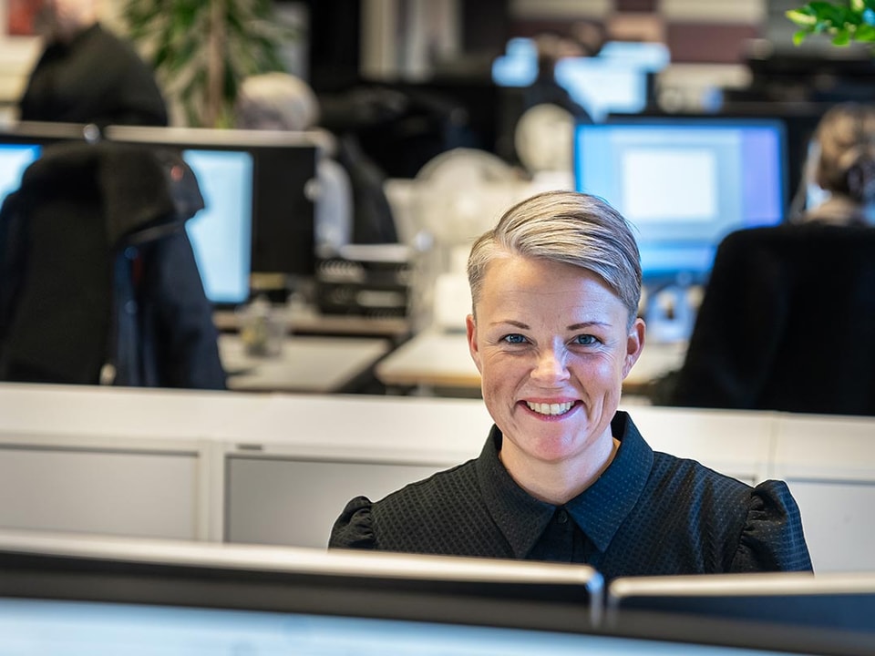Rådgiver i BN Bank sitter i kontorlokalet bak PC-skjerm, til illustrasjon for boliglånsrente